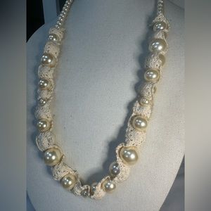 Long pearl bead necklace weaved around beige crochet accents